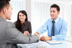 Business owners and financial consultant shaking hands over a table