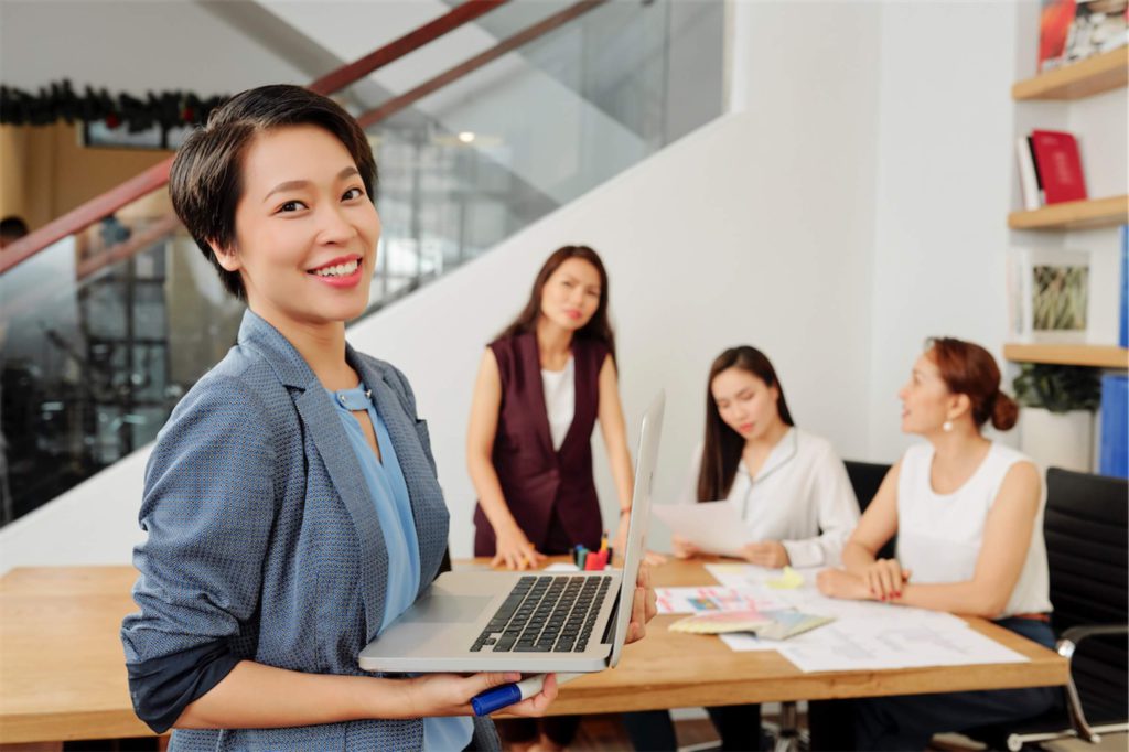 asian-businesswoman-smiling-with-an-opened-laptop