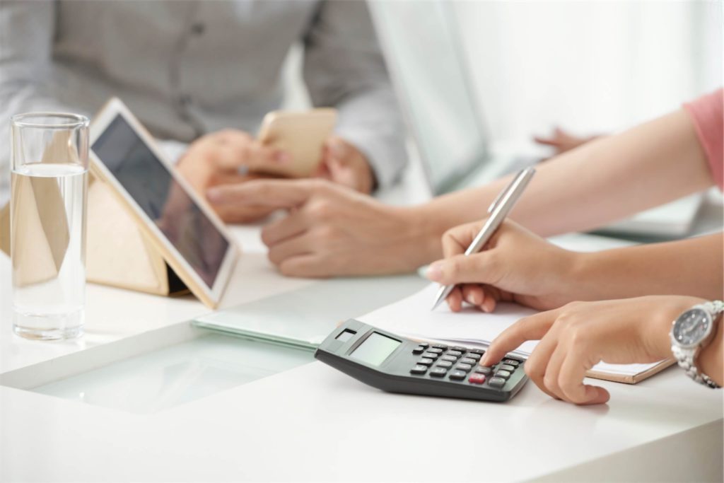 lady-using-calculator-and-signing-paper