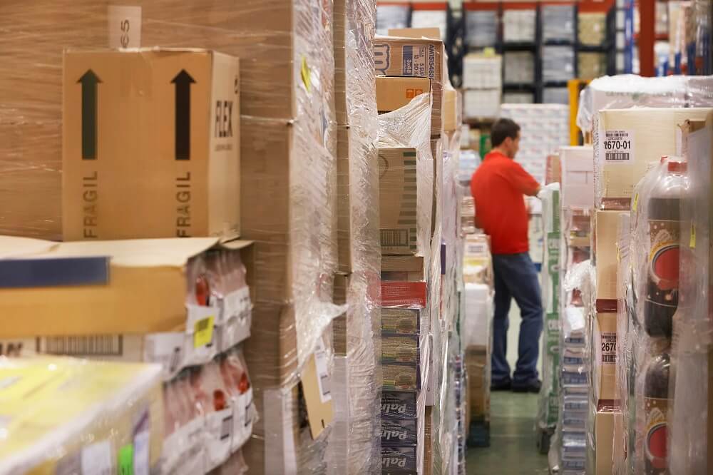 Man in the warehouse taking stock of his inventory, which is funded with a business loan
