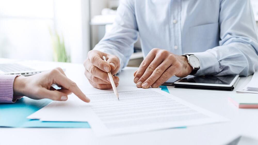 A lender going through payroll business loan contract terms with borrower