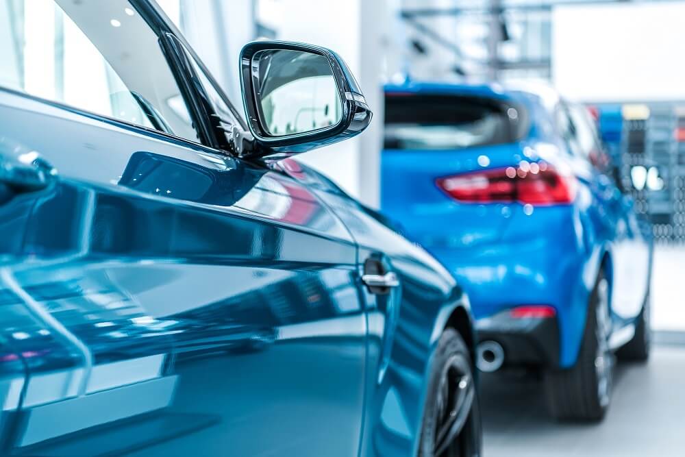 Side view of a blue car in a showroom where business loans like car flooring loans are available