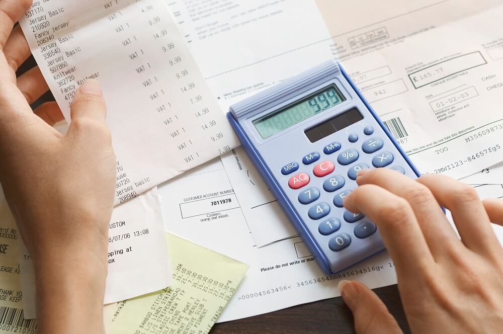 Woman calculating the cost of a merchant cash advance with a calculator