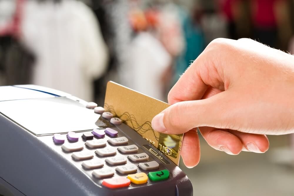 Woman swiping a credit card on a payment machine that’s hooked up to a merchant cash advance plan