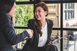 A business owner shaking hands with an SME loan broker