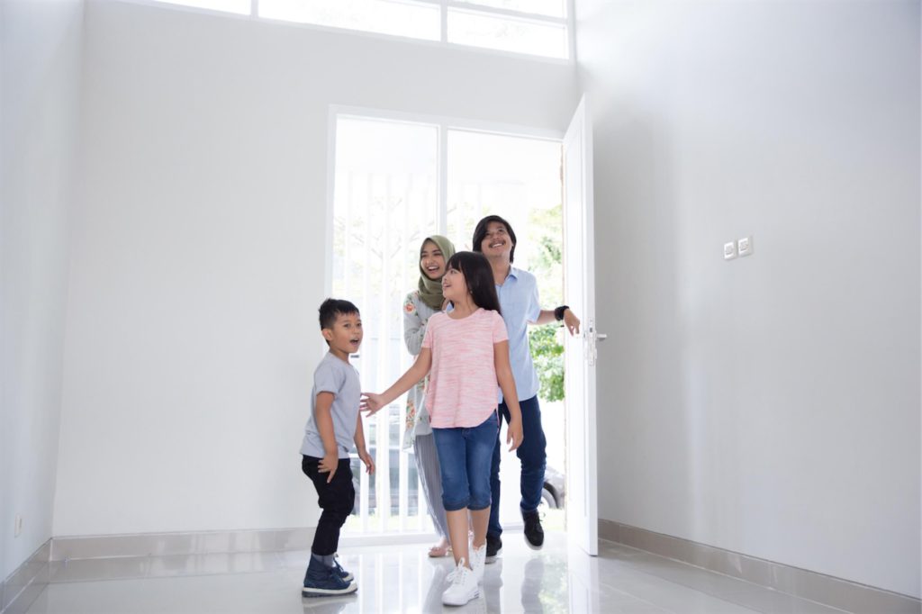 Family of four viewing their newly purchased house before getting a car loan